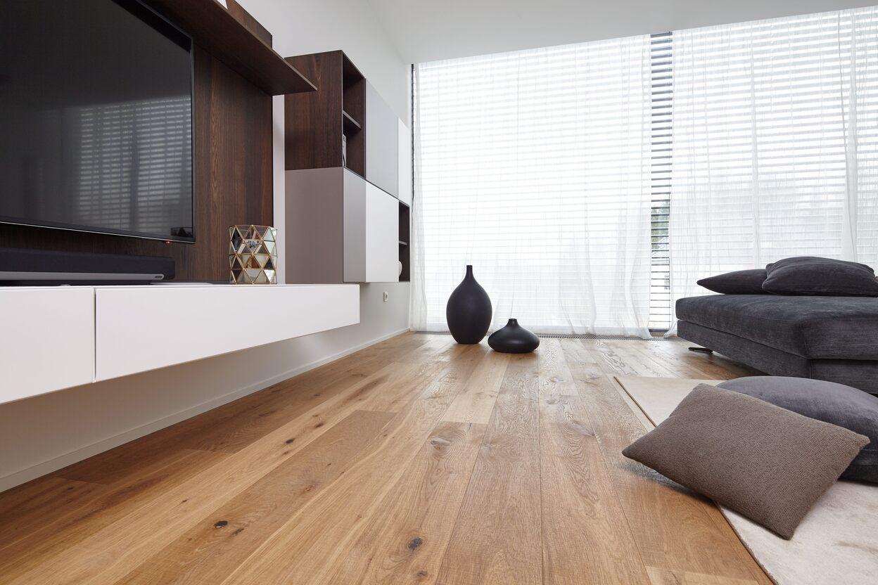 Wohnzimmer mit maßgefertigter Wohnwand und Echtholzparkett Modernes Wohnzimmer mit maßgefertigten Möbeln, Echtholzparkett und eleganter Wohnwand in Weiß und dunklem Holz.